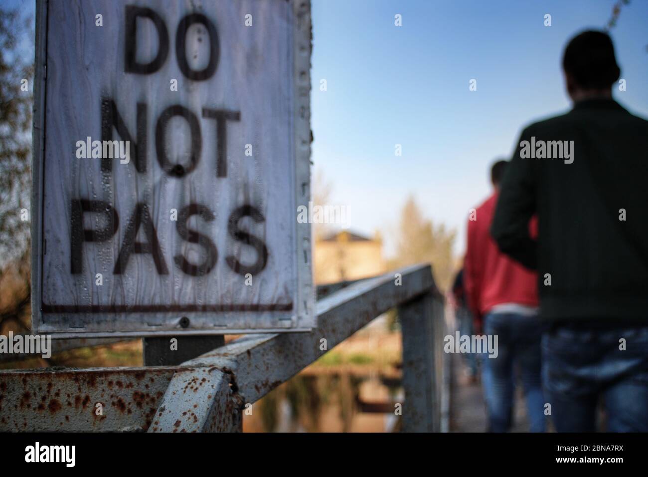 Un panneau « ne pas passer » sur un pont en délabrement à Tchernobyl, en Ukraine, est ignoré par un groupe de visiteurs touristiques sombres dans la zone d'exclusion de Tchernobyl. Banque D'Images