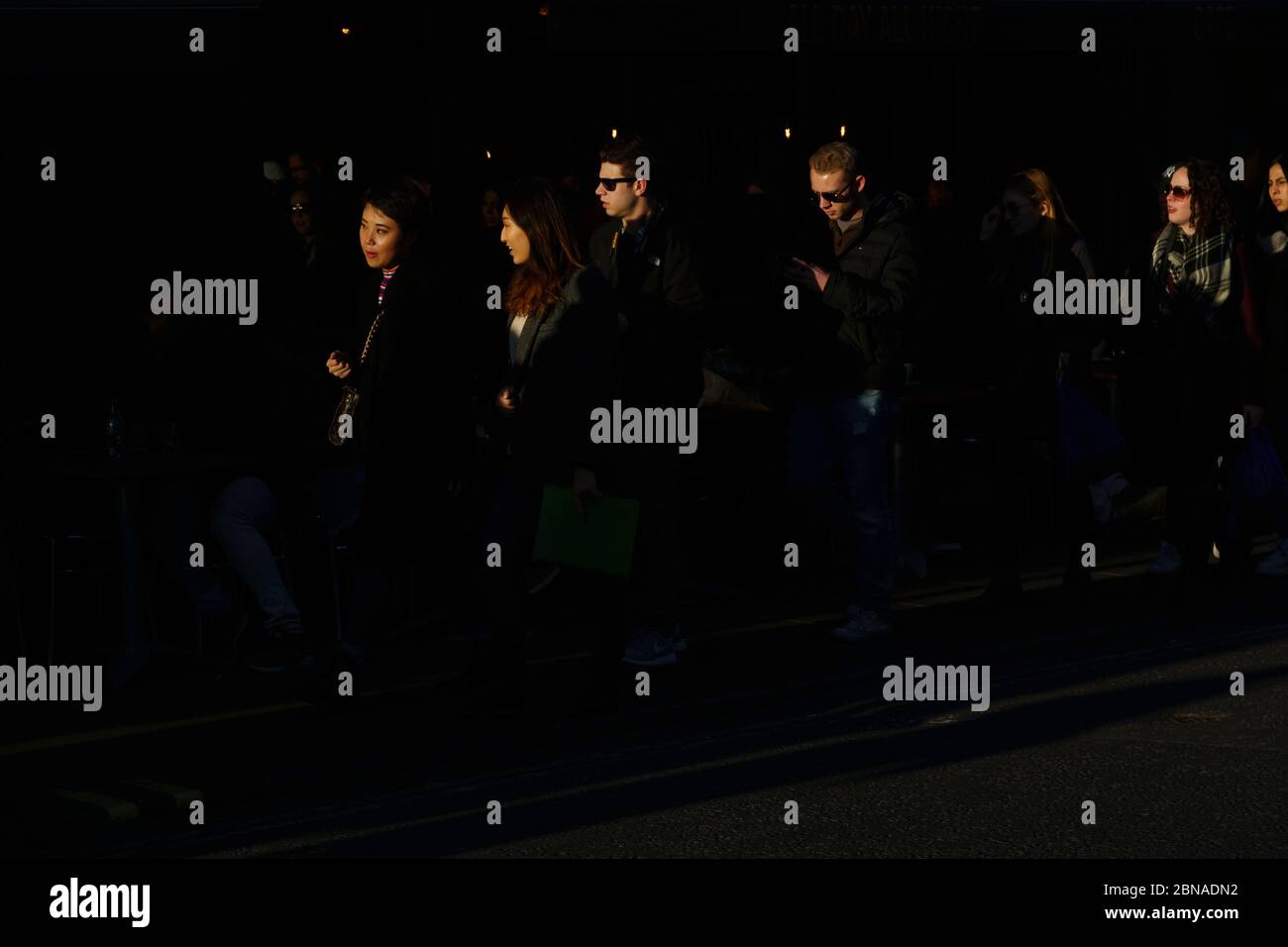 Personnes marchant dans la lumière dorée du soir, Old Compton Street, Londres, Royaume-Uni. 17 février 2018 Banque D'Images