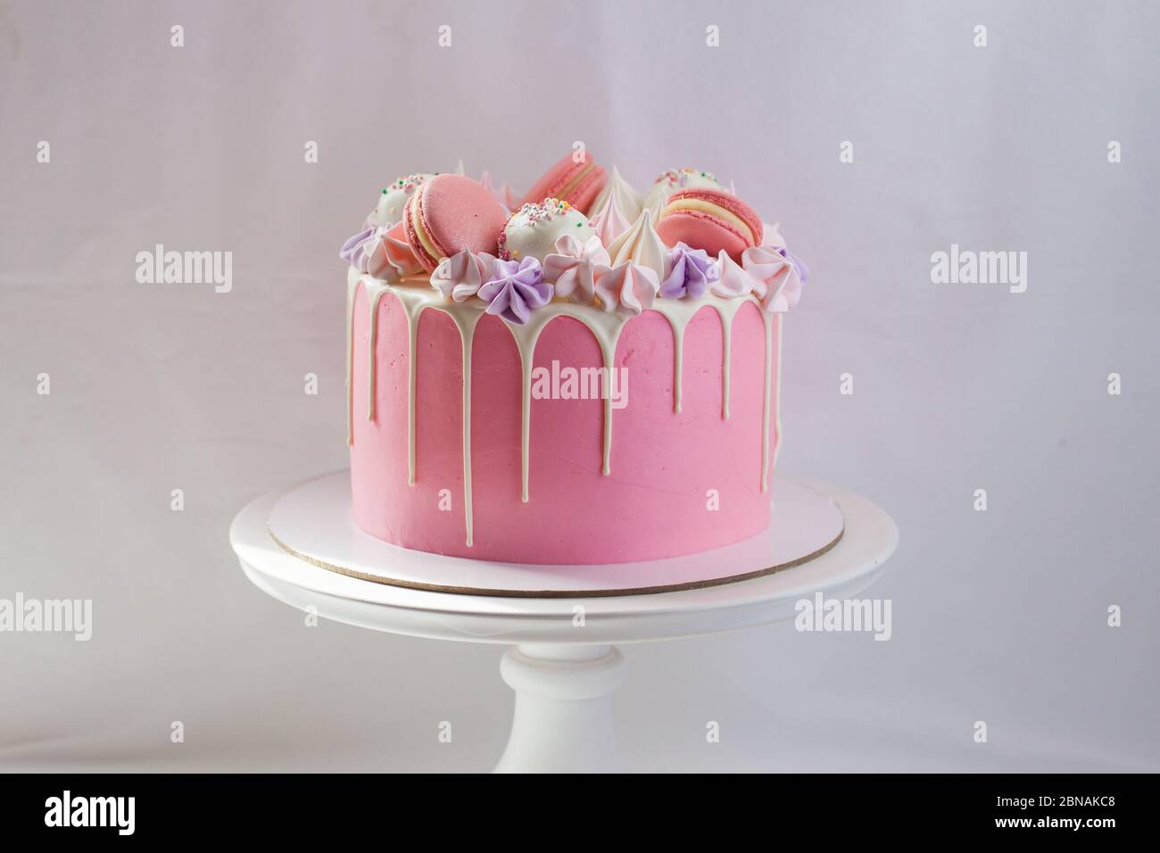 Gateau Rose Tendre Decore De Chocolat Blanc Fondu Macarons Meringues Pates A Gateau Et Bonbons Sur Cakestan Blanc Arriere Plan Simple Photo Stock Alamy