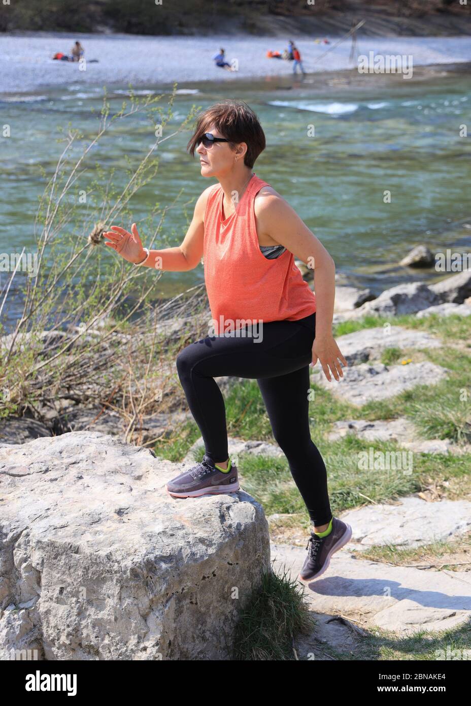 Femme, 40-45 ans, faisant un exercice sur les rives de l'Isar à Munich, Bavière, Allemagne. Banque D'Images