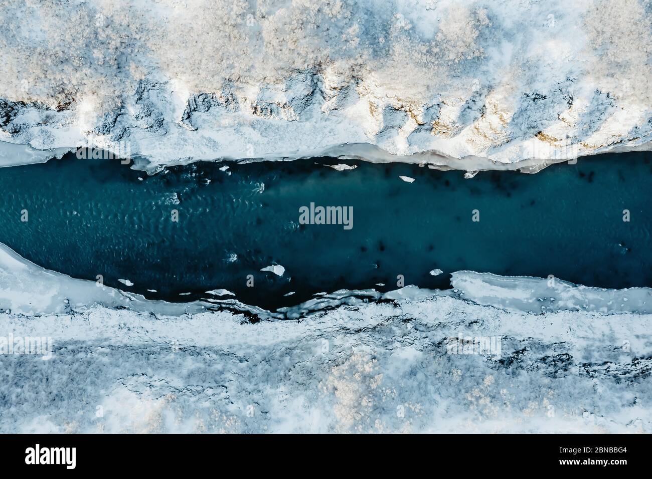 Vue aérienne d'une rivière en Islande avec eau turquoise, glace de fusion, changement climatique et concept de réchauffement planétaire Banque D'Images