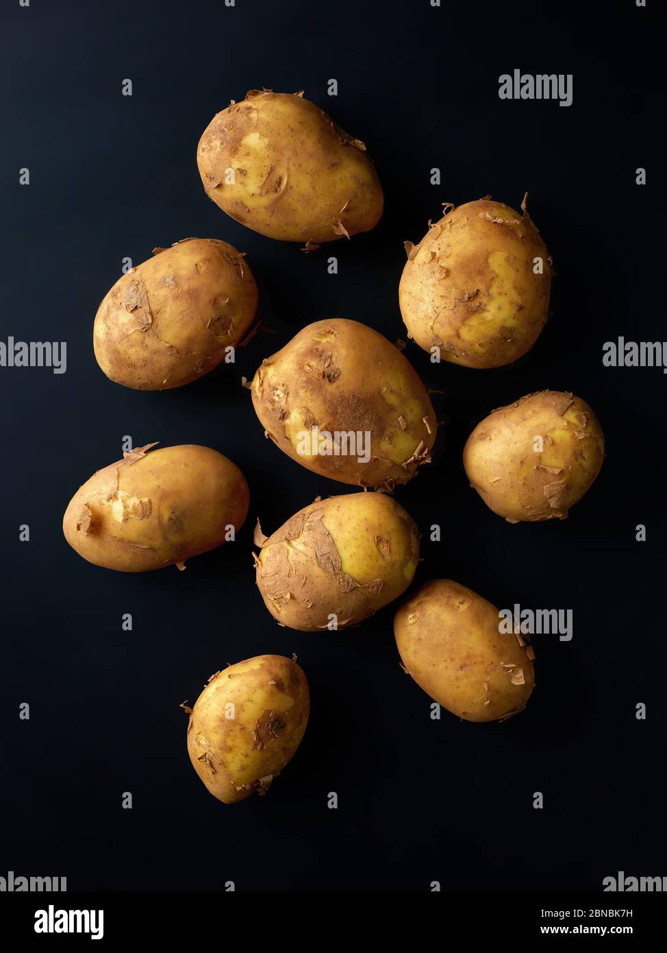 Tas de nouvelles pommes de terre sur fond noir, vue du dessus Banque D'Images