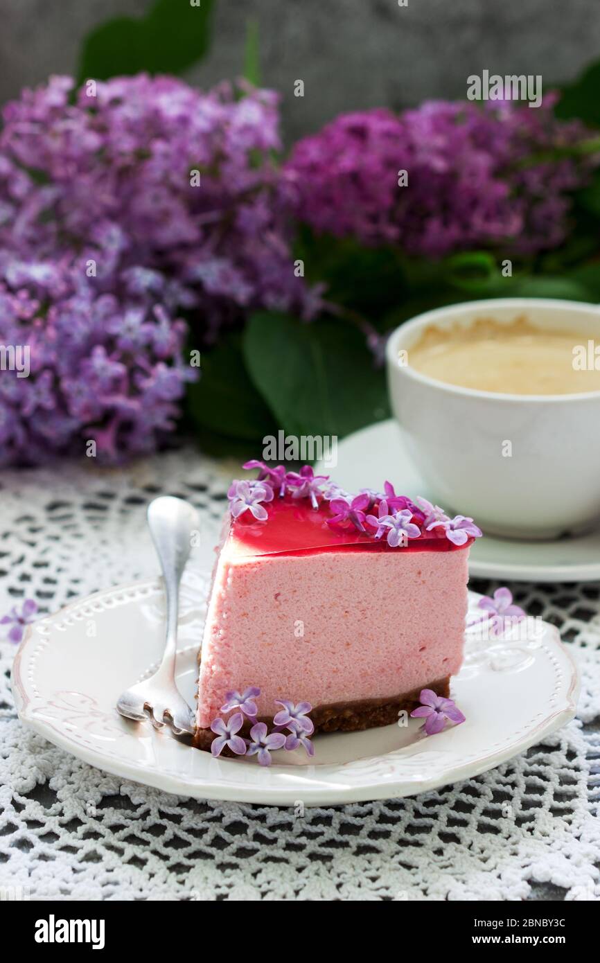 Un Gateau De Mousse Aux Baies A Base De Chocolat Et De Jus De Gelee Decore De Fleurs De Lilas Servi Avec Du Cafe Photo Stock Alamy