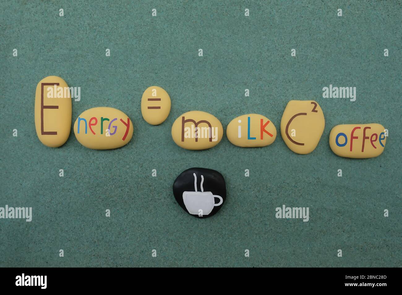 L'équation d'Einstein s'est adaptée à la puissance du café avec des pierres créatives sur le sable vert Banque D'Images