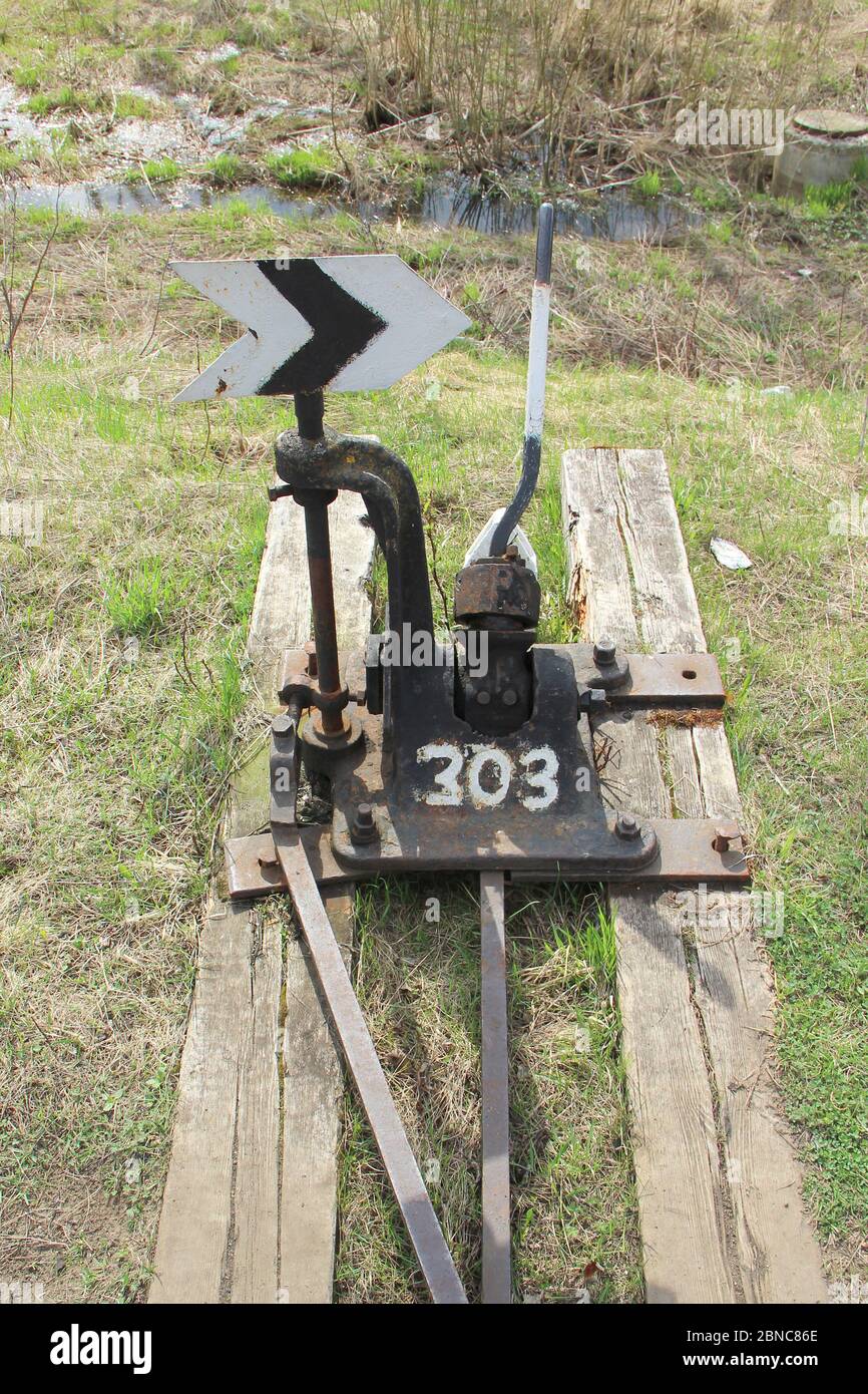 Flèche de chemin de fer en noir avec un levier et un pointeur en Russie. Dispositif de transfert de rails aux intersections pour les trains. Élément technique de l'industrie ferroviaire. Banque D'Images