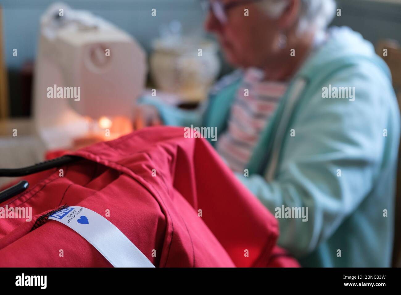 Pour l'amour des gommages, être fait par un volontaire à la table de salle à manger. C'est une charité qui fait des exfoliations (tuniques et pantalons) pour NHS Banque D'Images