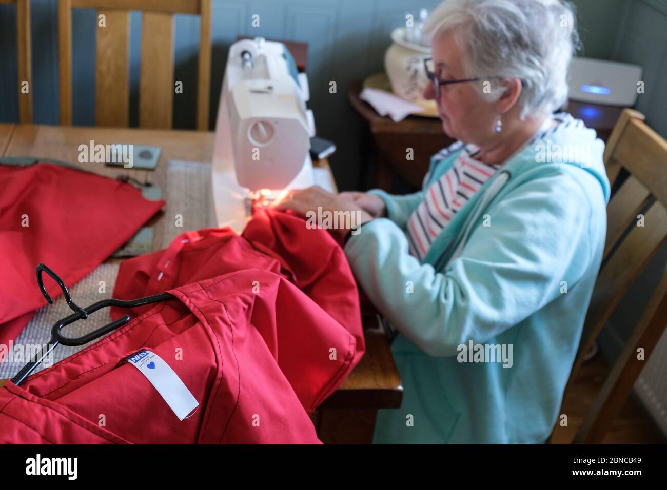 Pour l'amour des gommages, être fait par un volontaire à la table de salle à manger. C'est une charité qui fait des exfoliations (tuniques et pantalons) pour NHS Banque D'Images