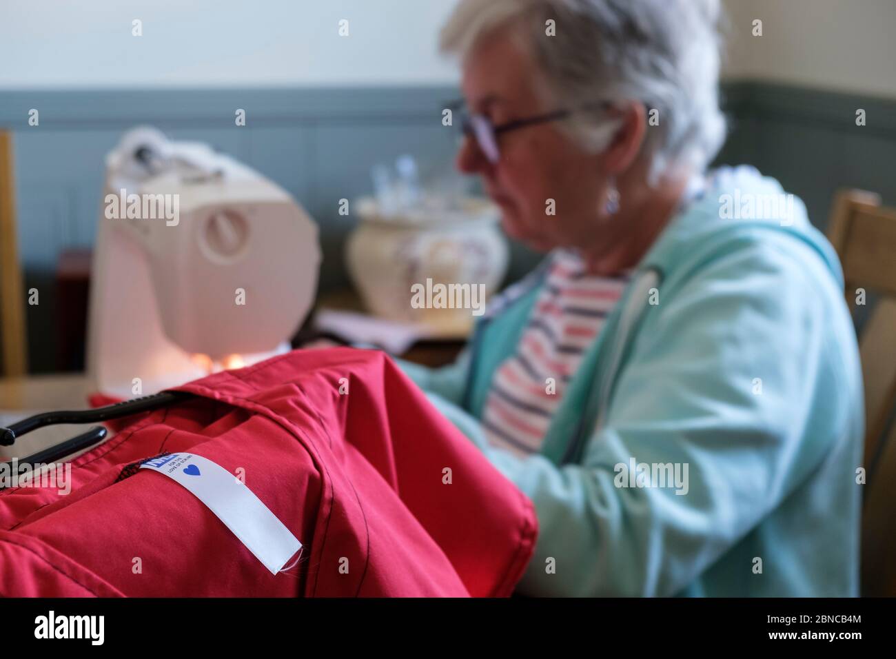 Pour l'amour des gommages, être fait par un volontaire à la table de salle à manger. C'est une charité qui fait des exfoliations (tuniques et pantalons) pour NHS Banque D'Images