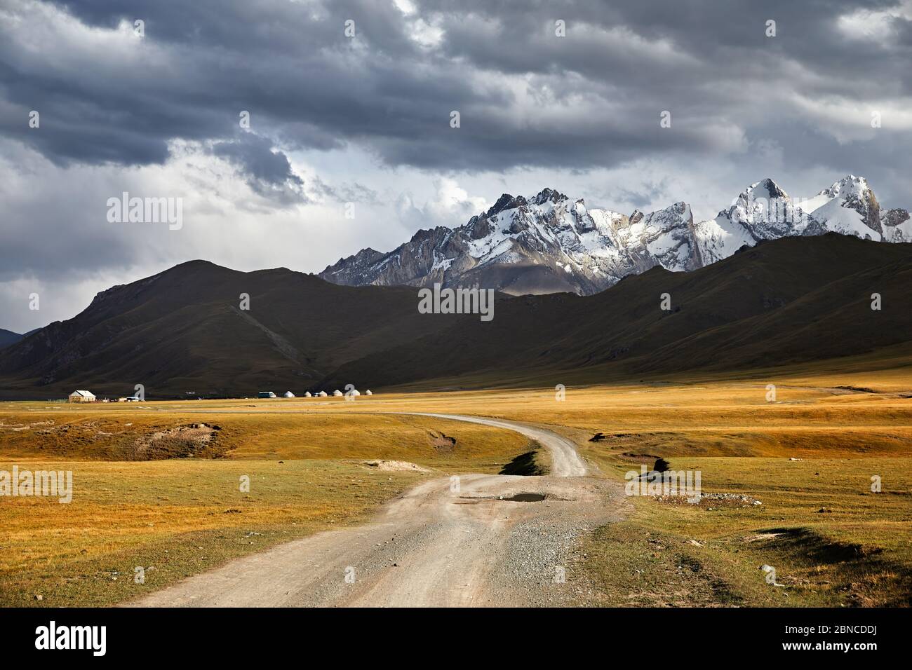 Beau paysage de montagnes de pics blancs, route et camp de yourte dans la vallée près du lac de Kel Suu dans la région de Naryn, au Kirghizstan Banque D'Images