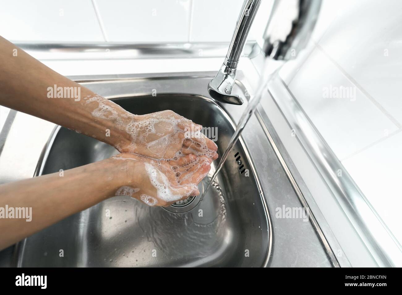 Femmes se lavant les mains avec du savon liquide pour prévenir et arrêter la propagation du virus corona - concept de personnel d'hygiène et de santé Banque D'Images