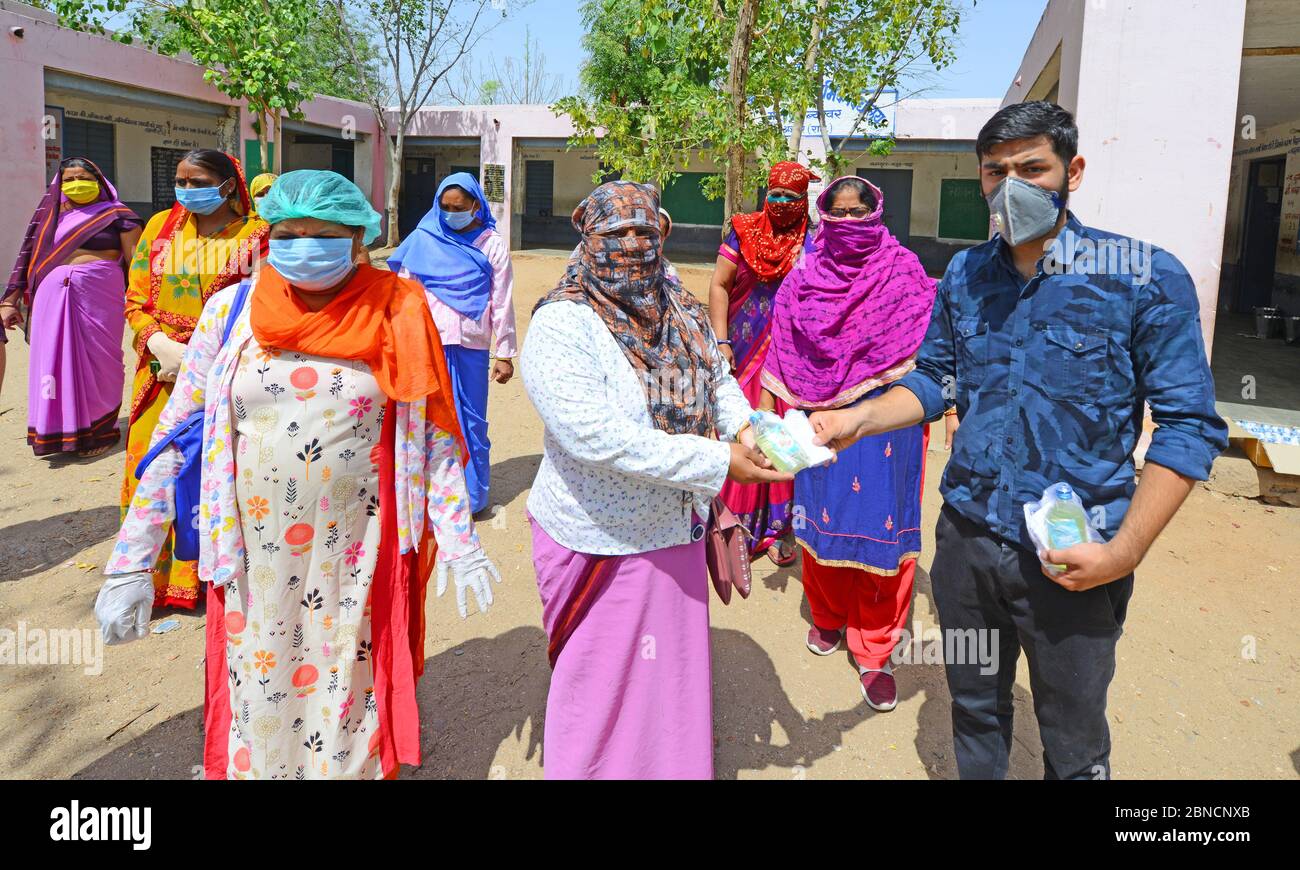 Le conseiller municipal et activiste social distribue des assainisseurs et des masques aux travailleurs d'Anganwadi dans une école publique de Beawar, Rajasthan, Inde, le 14 mai 2020. Les travailleurs d'Anganwadi effectuent une enquête de santé porte à porte pour vérifier la propagation du nouveau coronavirus dans la ville. (Photo de Sumit Saraswat / Pacific Press/Sipa USA) Banque D'Images