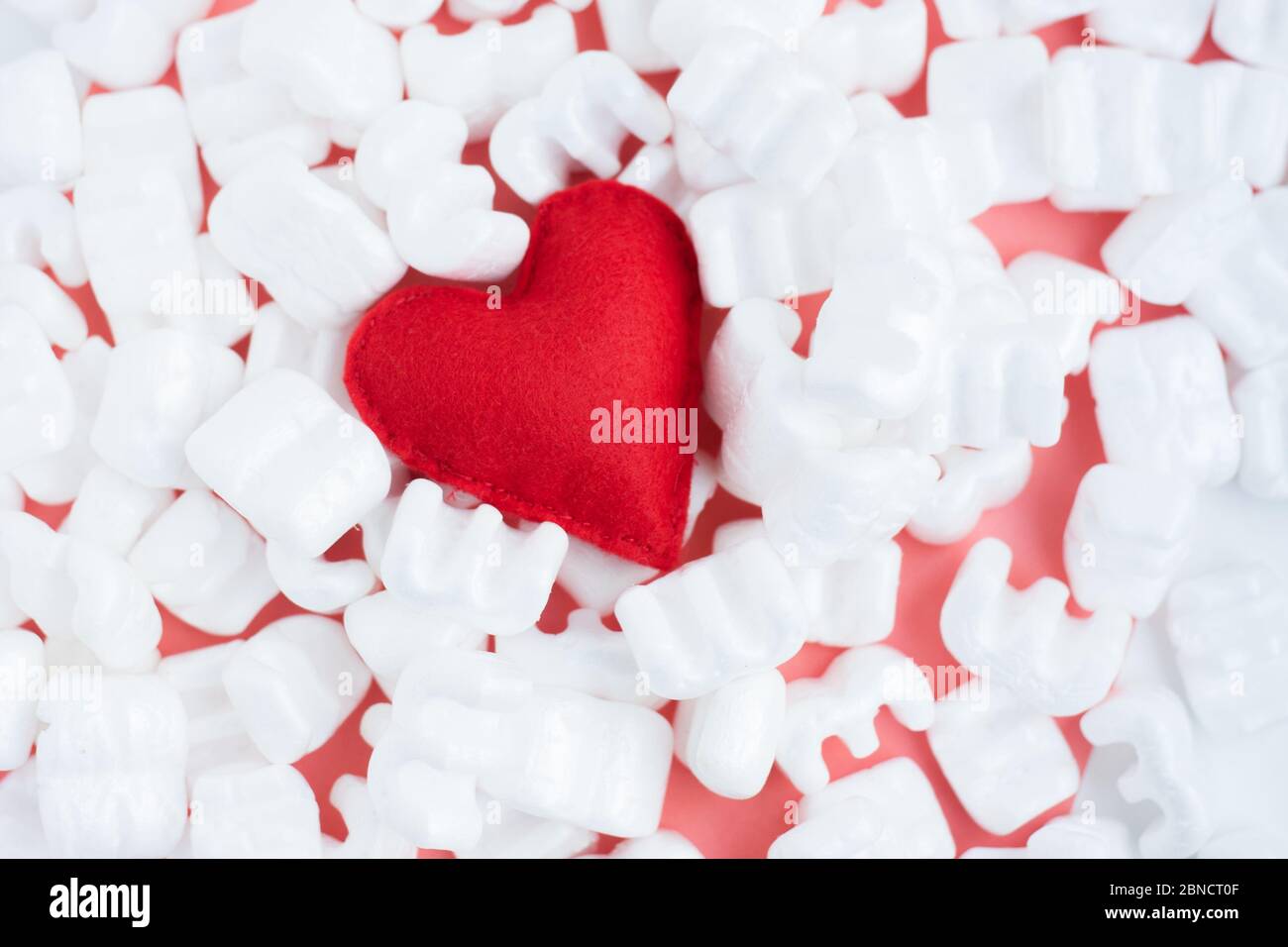 Cœur en feutre rouge sur les pastilles de styromousse blanc. Livraison avec amour. Sensibilité. S'occuper de l'amour Banque D'Images