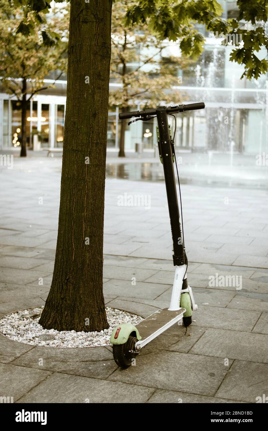 Plan vertical d'un scooter électrique et d'une fontaine l'arrière-plan Banque D'Images