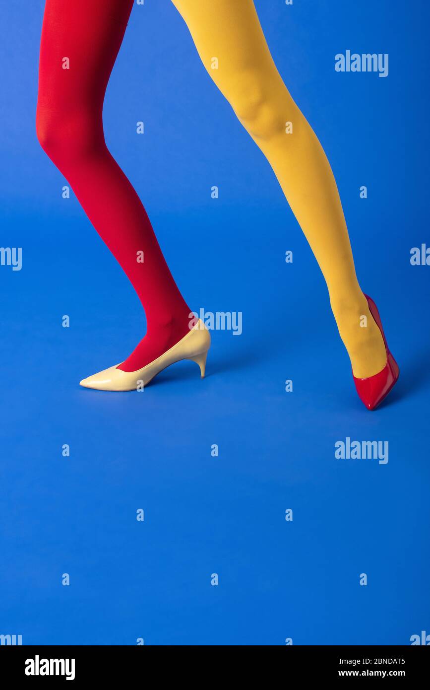 vue courte de la femme en collant jaune et rouge et chaussures posant sur  bleu Photo Stock - Alamy