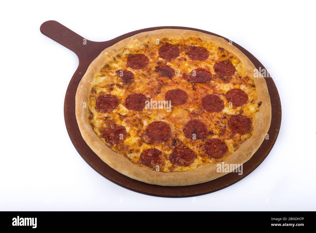 Délicieuse pizza sur une assiette en bois avec des garnitures de pepperoni Banque D'Images