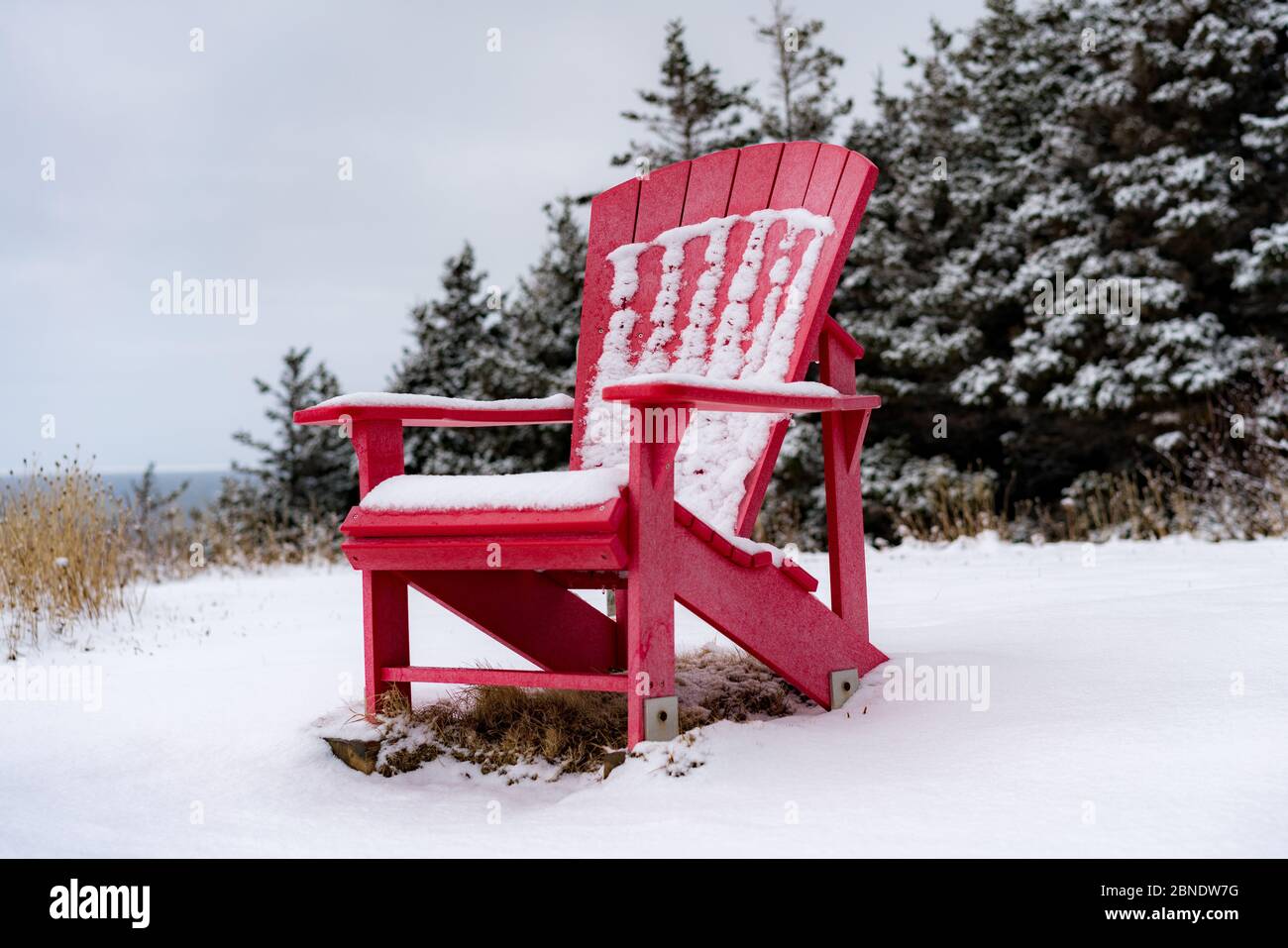 Chaise Red Muskoka dans la neige. Banque D'Images