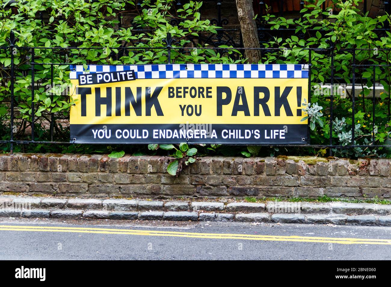 Une bannière sur les rampes à l'extérieur d'une école lisant « pensez avant de vous garer » demandant aux automobilistes d'être polis et de se garer soigneusement, North London, Royaume-Uni Banque D'Images