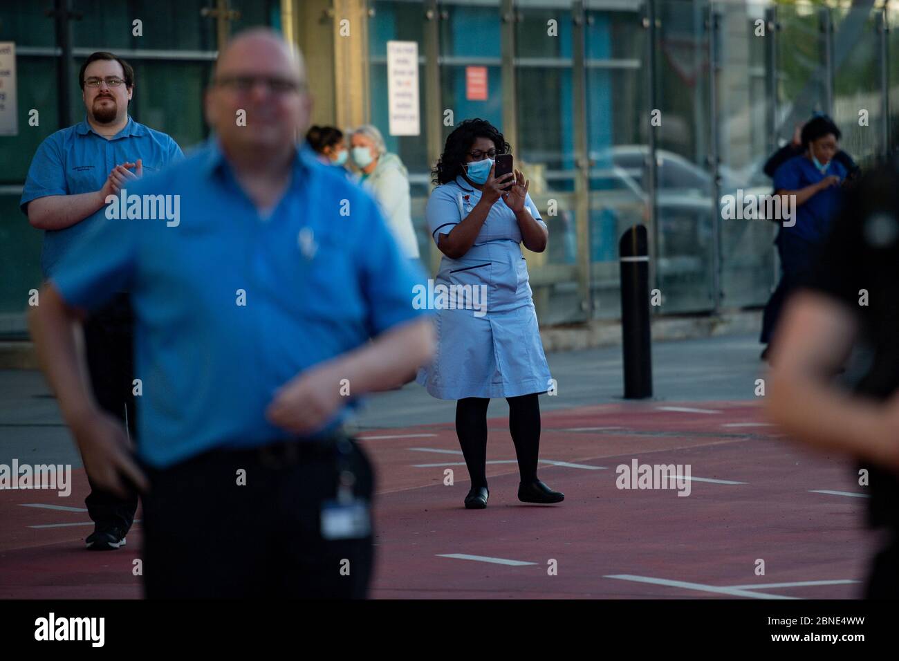Le personnel du NHS à l'extérieur de l'hôpital Queen Elizabeth de Birmingham, alors qu'il se joint aux applaudissements pour saluer les héros locaux lors du Clap national de jeudi pour que les soignants reconnaissent et soutiennent les travailleurs du NHS et les soignants qui luttent contre la pandémie du coronavirus. Banque D'Images
