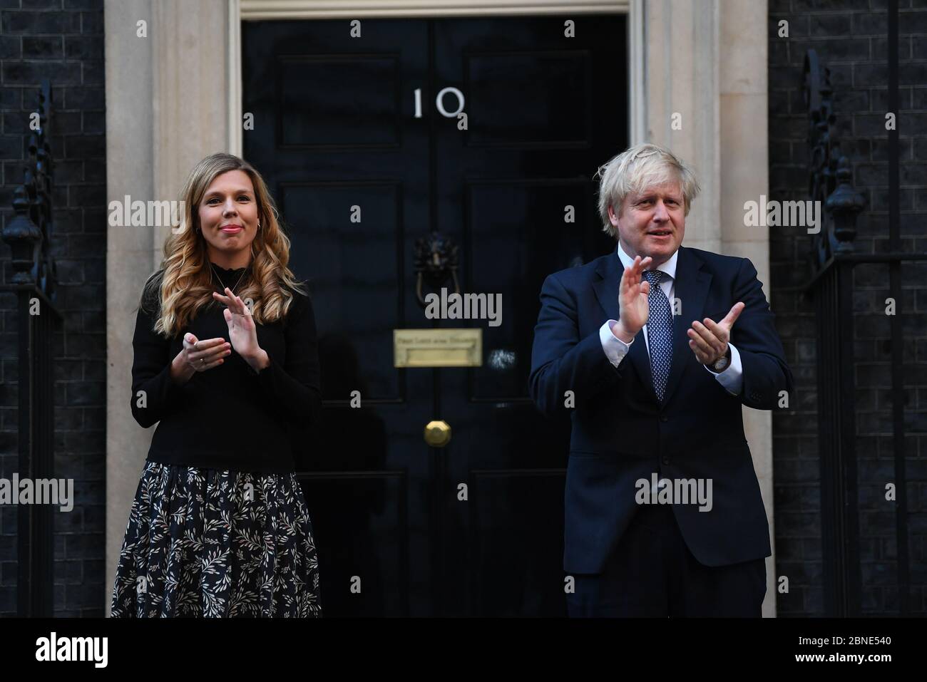 Le Premier ministre Boris Johnson et sa partenaire Carrie Symonds, se tiennent à Downing Street, Londres, pour se joindre aux applaudissements pour saluer les héros locaux lors du Clap national de jeudi pour que les soignants reconnaissent et soutiennent les travailleurs du NHS et les soignants qui luttent contre la pandémie du coronavirus. Banque D'Images