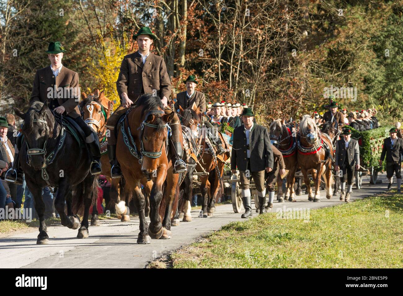 Deux cavaliers et deux calèches tirés par quatre chevaux défilant pendant le Leonhardiritt ou Leonhardifahrt, la procession traditionnelle de Saint Léonard Banque D'Images