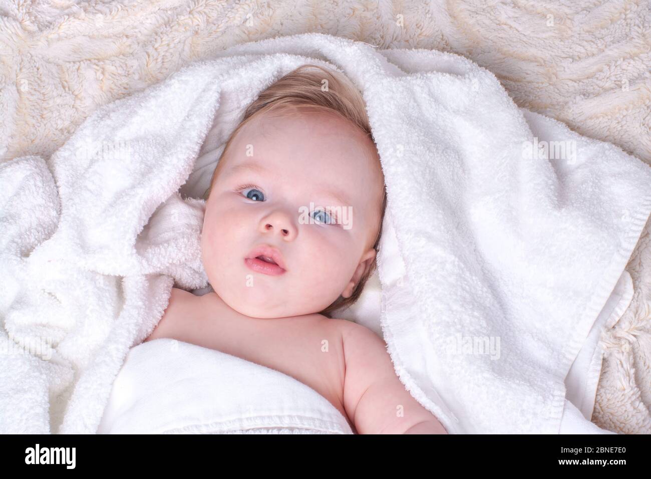 Surprise Nouveau Ne Bleu Eyed Garcon Avec Des Levres Et Des Cheveux Blonds Se Trouve Dans Une Serviette Seche Blanche Sur La Couverture Legere Duveteuse Apres Avoir Baigne Dans La Salle De Bains Textiles