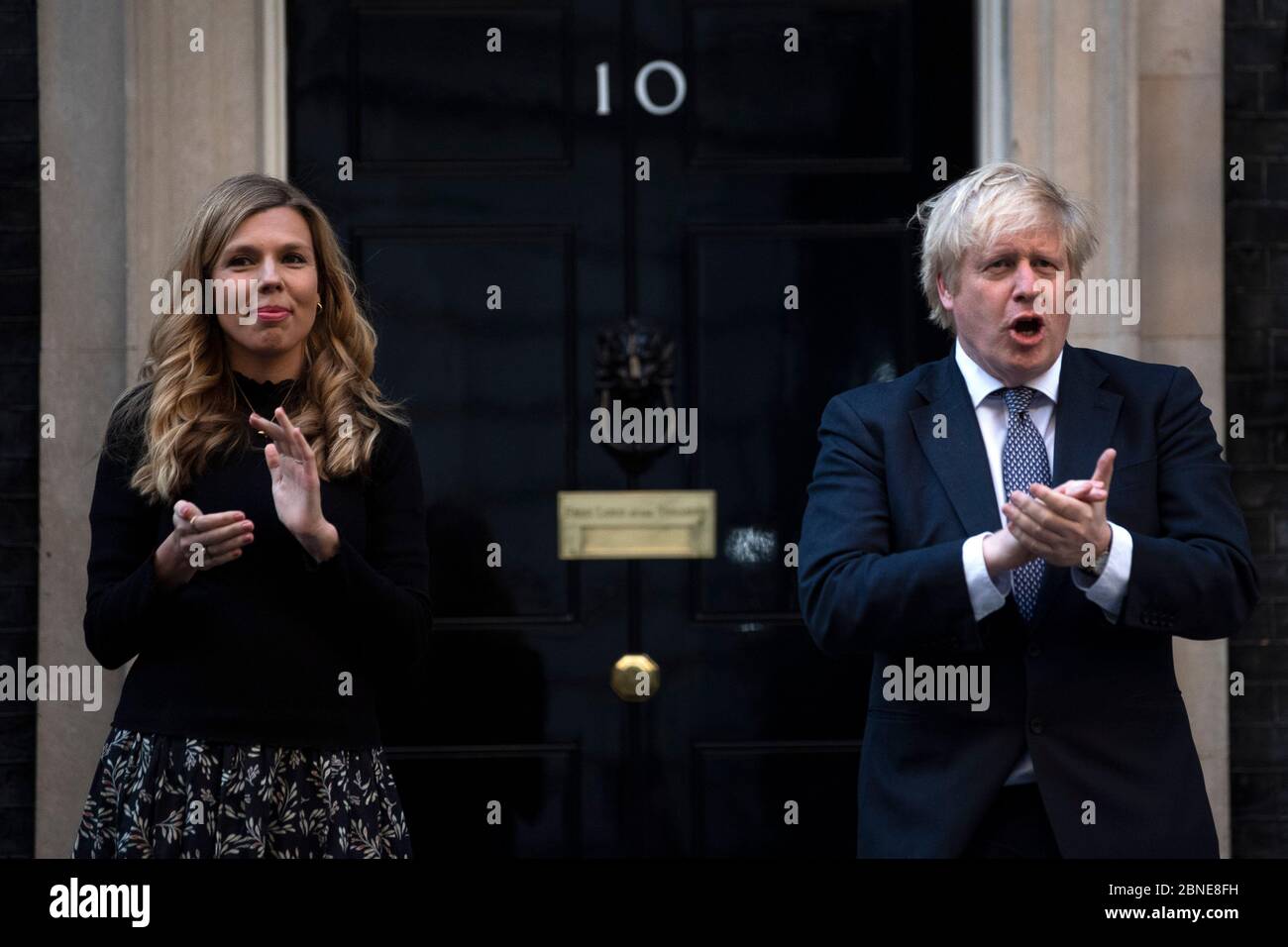 Le Premier ministre Boris Johnson et Carrie Symonds se tiennent à Downing Street, Londres, pour se joindre aux applaudissements pour saluer les héros locaux lors du Clap dans tout le pays jeudi pour que les soignants reconnaissent et soutiennent les travailleurs du NHS et les soignants qui luttent contre la pandémie du coronavirus. Banque D'Images