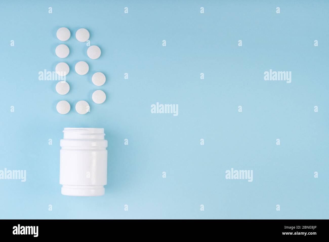 Les comprimés de vitamine B sont tombés du flacon sur le bleu. Inscription de la lettre B sur les comprimés. Vitamine B12 concept. Concept de protection de l'immunité, prévention antivirale Banque D'Images