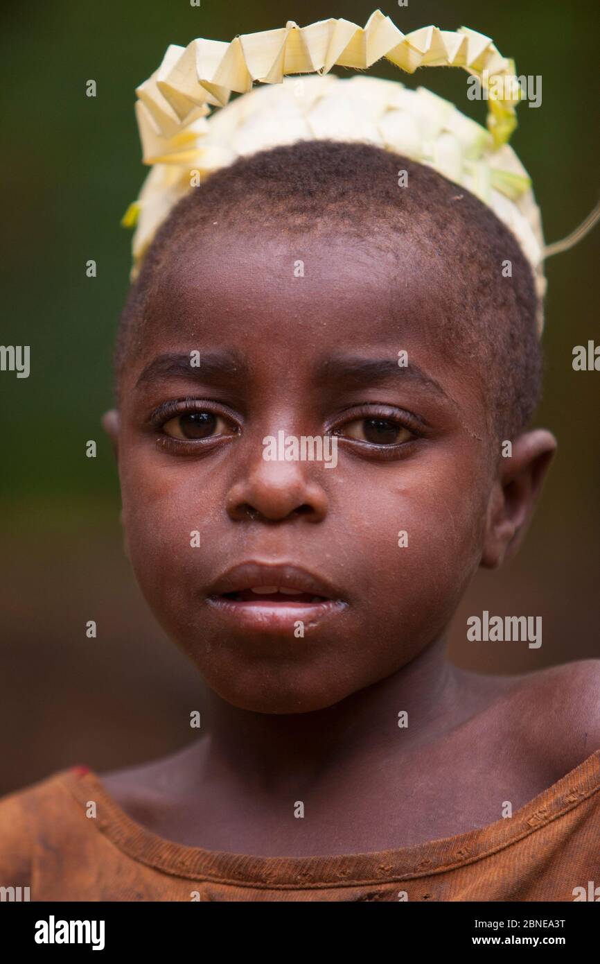 Baka garçon portant une couronne de fibre nouvellement faite pour une cérémonie de nuit, Sud-est Cameroun, juillet 2008. Banque D'Images