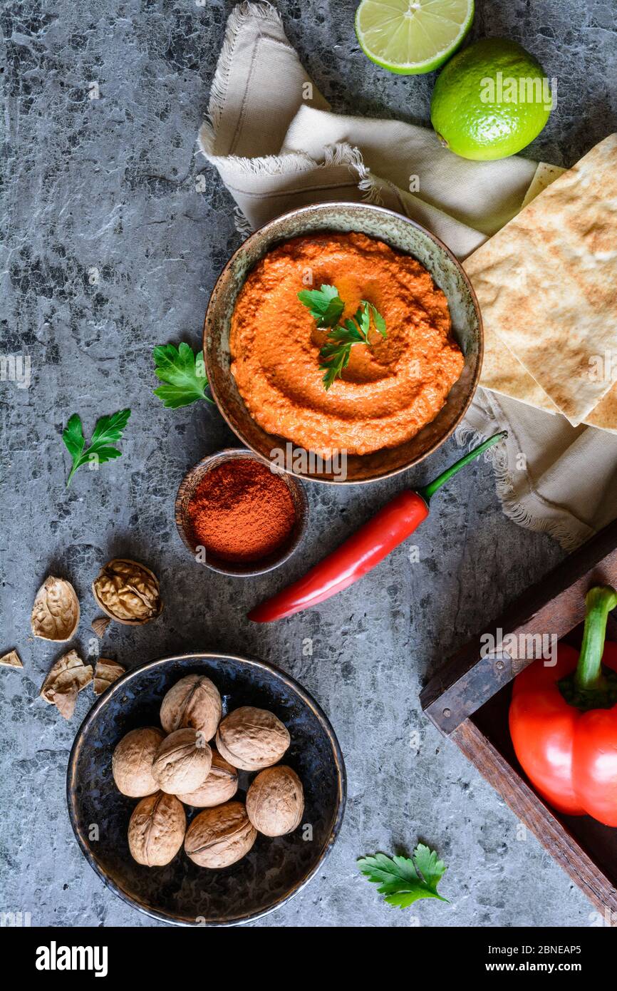 Muhammara, une sauce saine aux noix et au poivron rouge rôti servi avec du pain plat dans un bol en céramique Banque D'Images