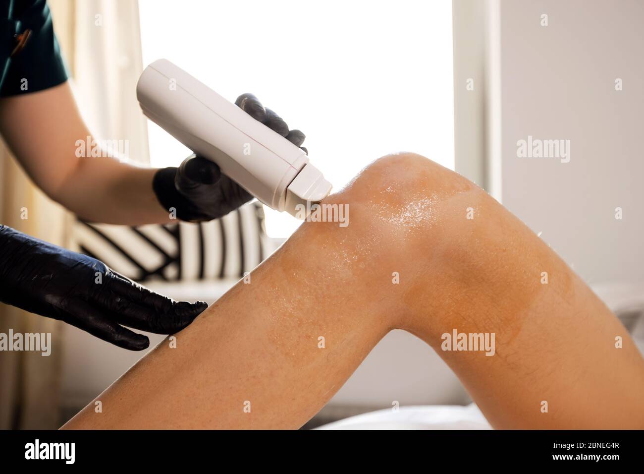 Femme cire ou sugaring maître applique la cire chaude à l'aide de la machine Banque D'Images