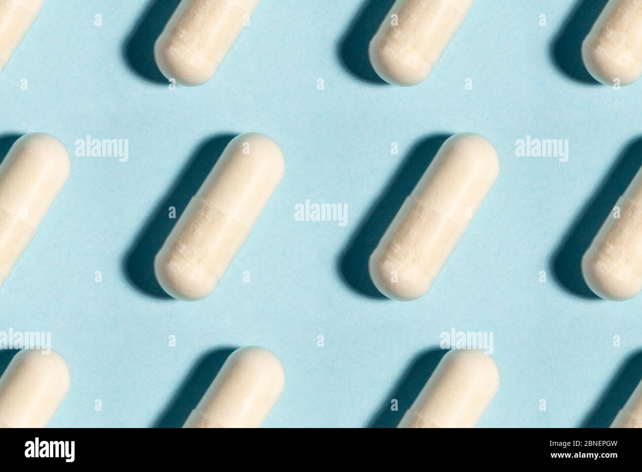 Comprimé médical sans couture, modèle de capsule de médecine pharmaceutique. Analgésique, vitamine, antibiotique, probiotique sur fond bleu. Concept médical. Scienc Banque D'Images
