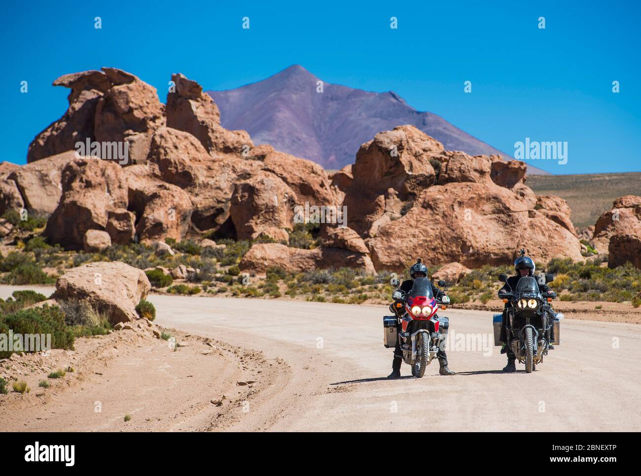 Deux amis qui voyagent en moto sur une route poussiéreuse en Bolivie Banque D'Images
