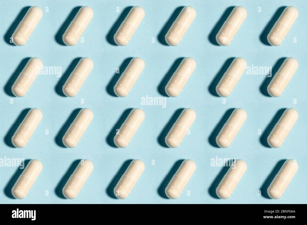 Comprimé médical sans couture, modèle de capsule de médecine pharmaceutique. Analgésique, vitamine, antibiotique, probiotique sur fond bleu. Concept médical. Scienc Banque D'Images