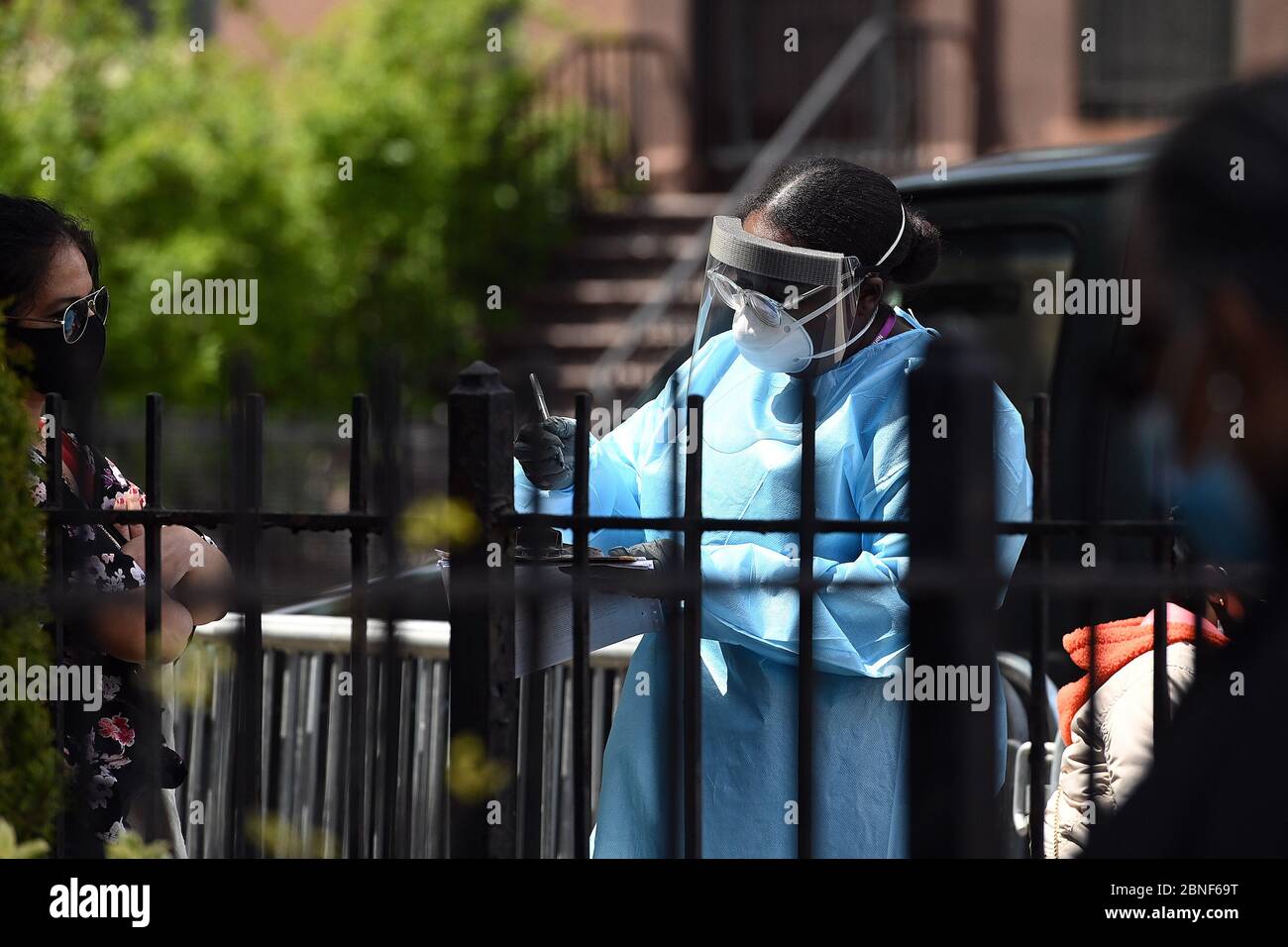 New York, États-Unis. 14 mai 2020. Un professionnel de la santé s'occupe de personnes qui attendent en file d'attente à l'extérieur de l'église baptiste de Bethany pour être testé pour COVID-19, dans le quartier Bedford-Stuyvesant de Brooklyn, NY, le 14 mai 2020. 11 les églises de la ville de New York dans les quartiers à faible revenu ont commencé à offrir des tests pour le COVID-19, afin de limiter les taux plus élevés d'infection à coronavirus dans les communautés minoritaires. (Anthony Behar/Sipa USA) crédit: SIPA USA/Alay Live News Banque D'Images