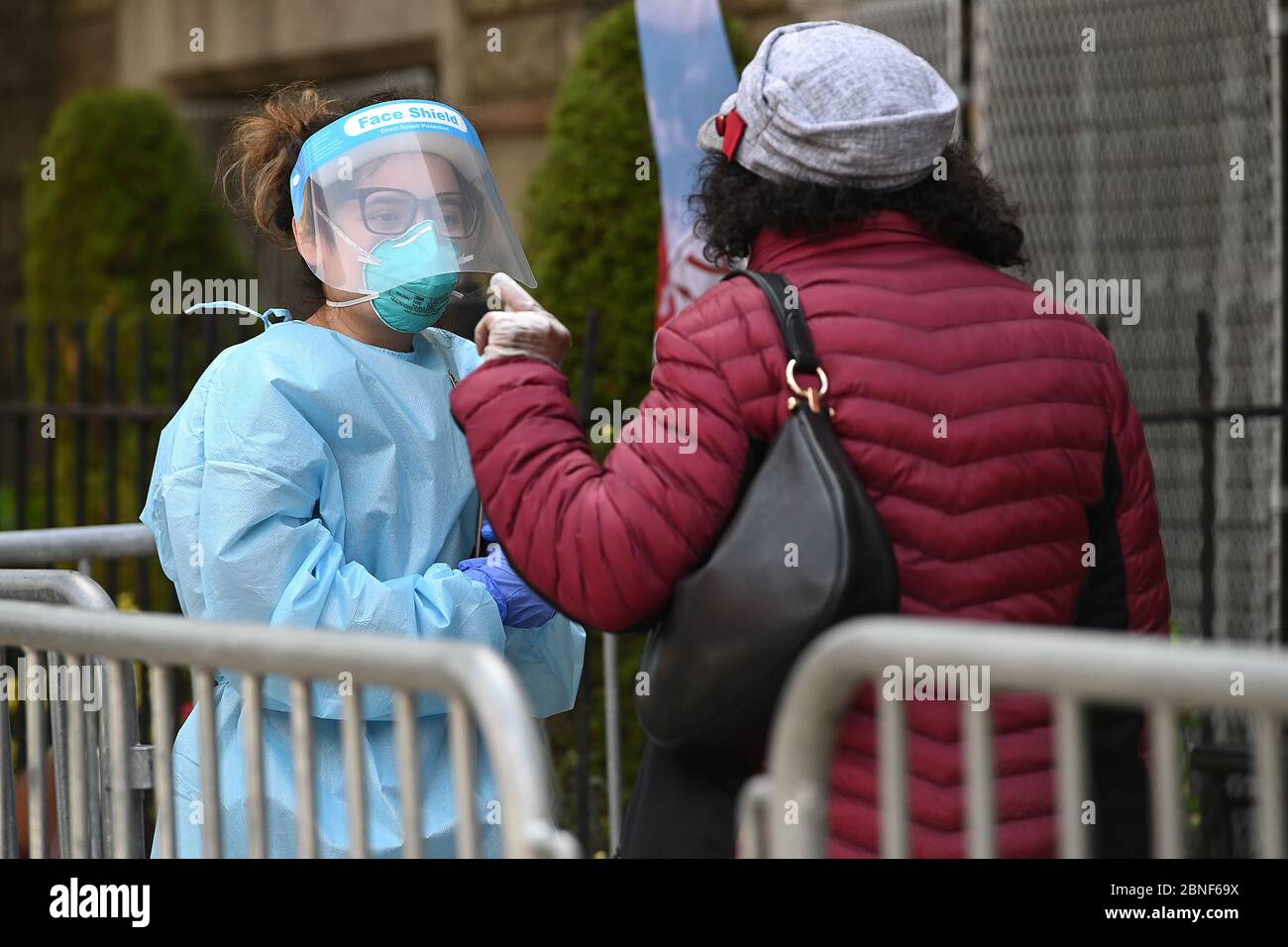 New York, États-Unis. 14 mai 2020. Un professionnel de la santé s'occupe d'une femme qui attend en file d'attente à l'extérieur de l'église baptiste de Bethany pour être testée pour la COVID-19, dans le quartier Bedford-Stuyvesant de Brooklyn, NY, le 14 mai 2020. 11 les églises de la ville de New York dans les quartiers à faible revenu ont commencé à offrir des tests pour le COVID-19, afin de limiter les taux plus élevés d'infection à coronavirus dans les communautés minoritaires. (Anthony Behar/Sipa USA) crédit: SIPA USA/Alay Live News Banque D'Images