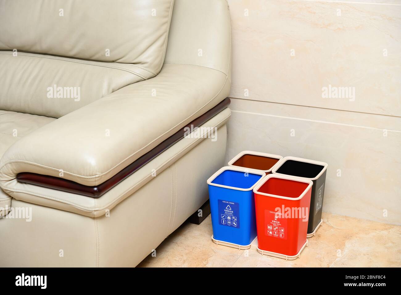 poubelles de classification près d'un canapé dans un salon à la maison  traduction-caractères bleus signifie déchets recyclables rouge un signifie  noir nocif une moyenne Photo Stock - Alamy