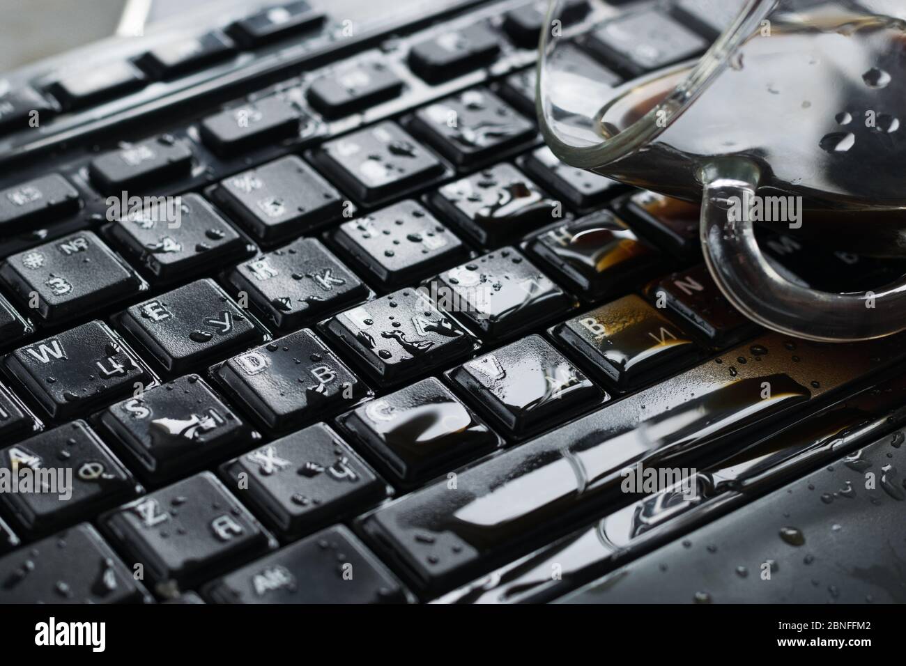 café renversé sur un clavier noir en gros plan Banque D'Images café renversé sur un clavier noir en gros plan Banque D'Images