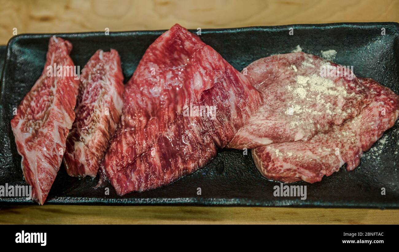Bœuf Wagyu japonais finement coupé en tranches sur la grille pour barbecue. Faites griller l'un des meilleurs bœuf du Japon. Style Yakiniku, qui signifie cuisine de viande grillée. Plats pour barbecue. Banque D'Images