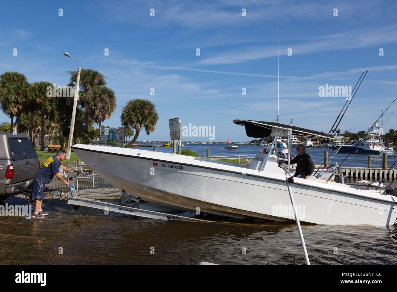 Deux hommes récupèrent leur bateau de pêche de Manatee Pocket sur la rampe d'accès pour bateaux du parc Sandscrit à Port Salerno, Floride, États-Unis. Banque D'Images