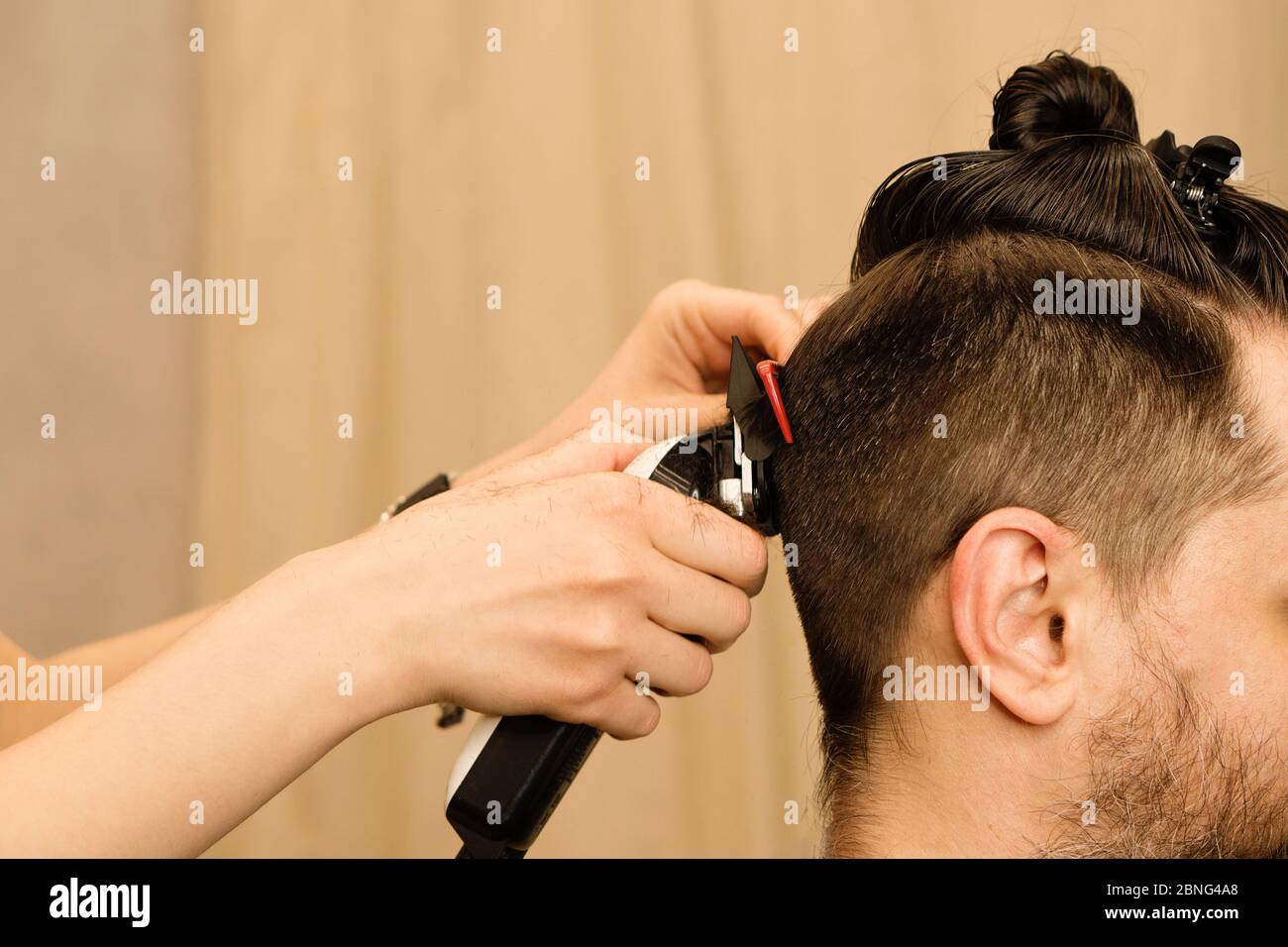 Rasoir électrique coupe de cheveux pour hommes. Main de coiffeur rasse les  cheveux avec un rasoir électrique. Hipster homme obtient une coupe de  cheveux tendance avec une tondeuse à cheveux et un