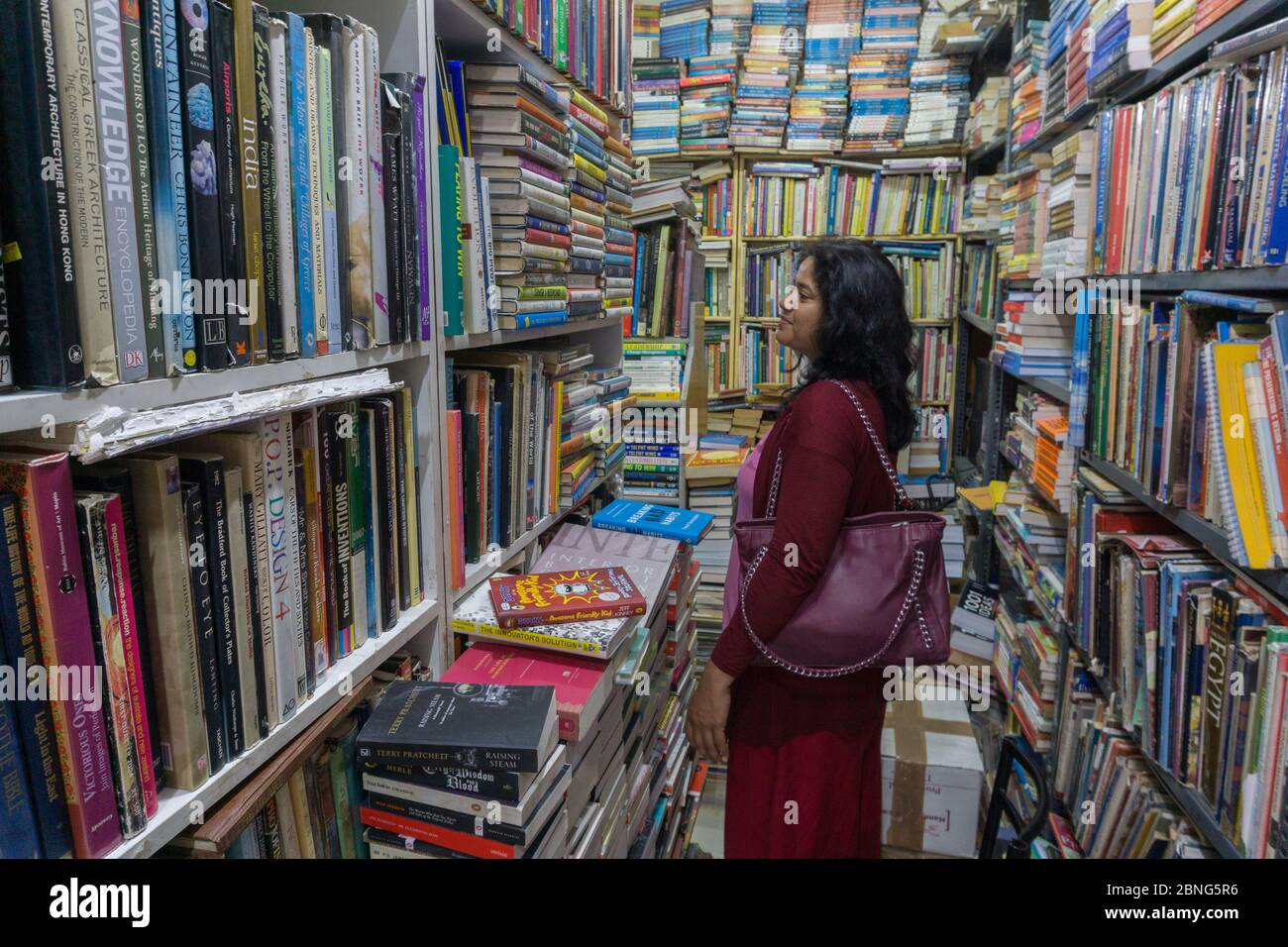 Une dame parcourant les livres dans un magasin de livres situé dans Church Street à Bangalore (Inde) Banque D'Images