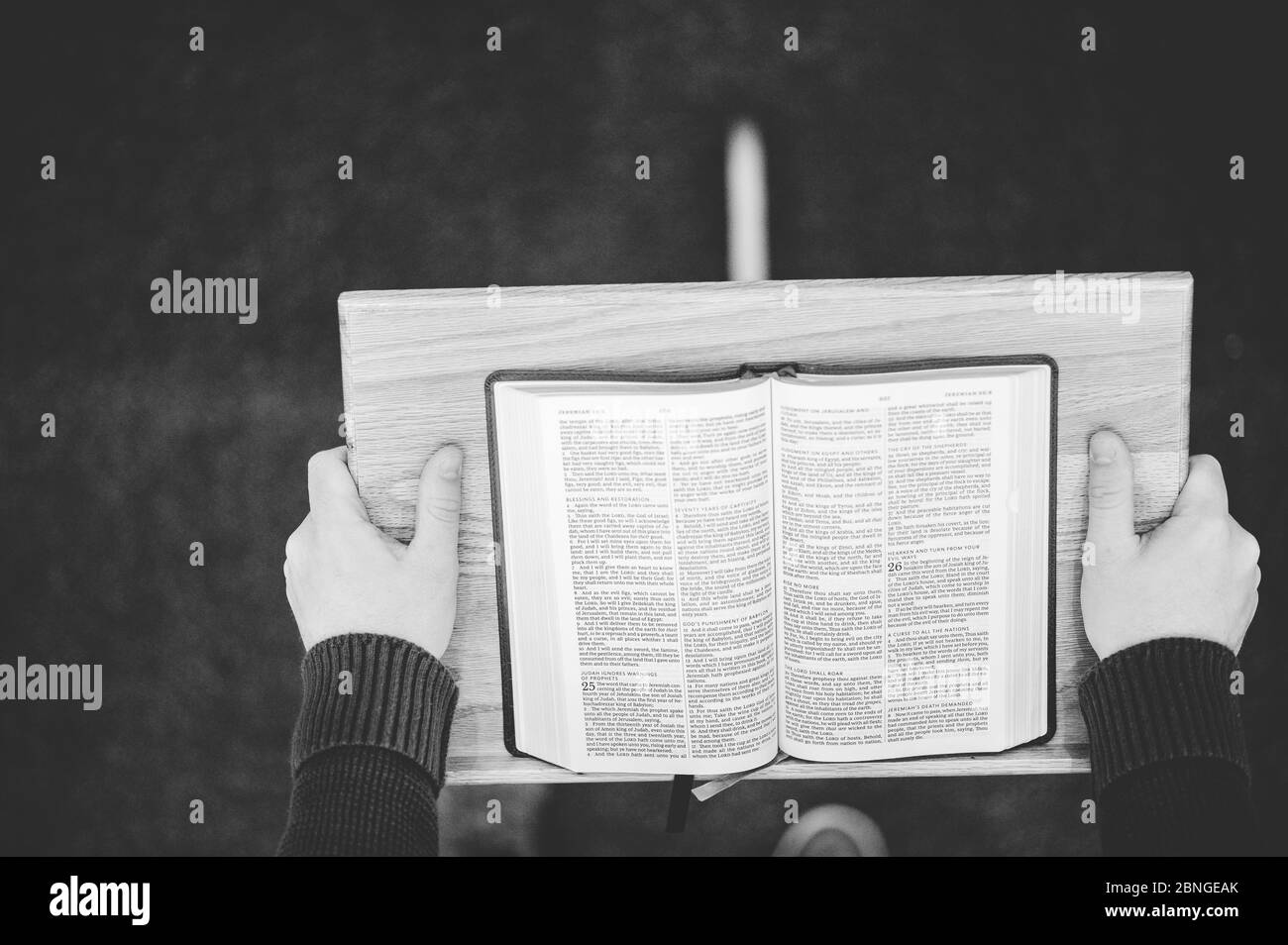 Cliché en échelle de gris d'une personne prêchant la Sainte Bible la tribune à l'autel de l'église Banque D'Images