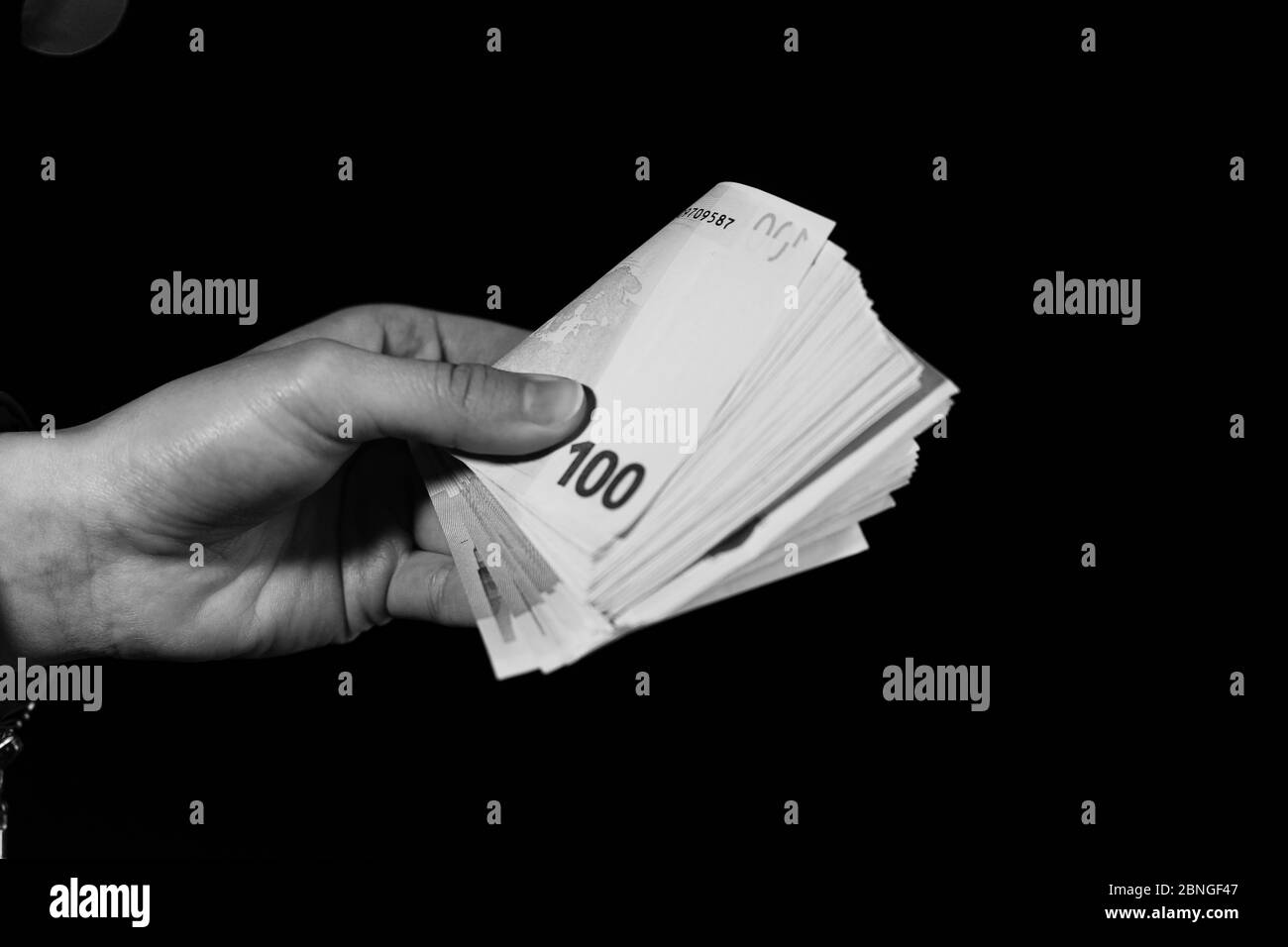 Comptage manuel de la main tenant et montrant de l'argent en euros ou donnant de l'argent. World Money concept, 100 BILLETS EN EUROS monnaie en euros isolée sur noir avec espace de copie. Banque D'Images