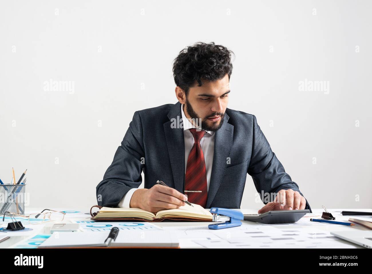 Homme d'affaires arabe calculant le budget au bureau Banque D'Images