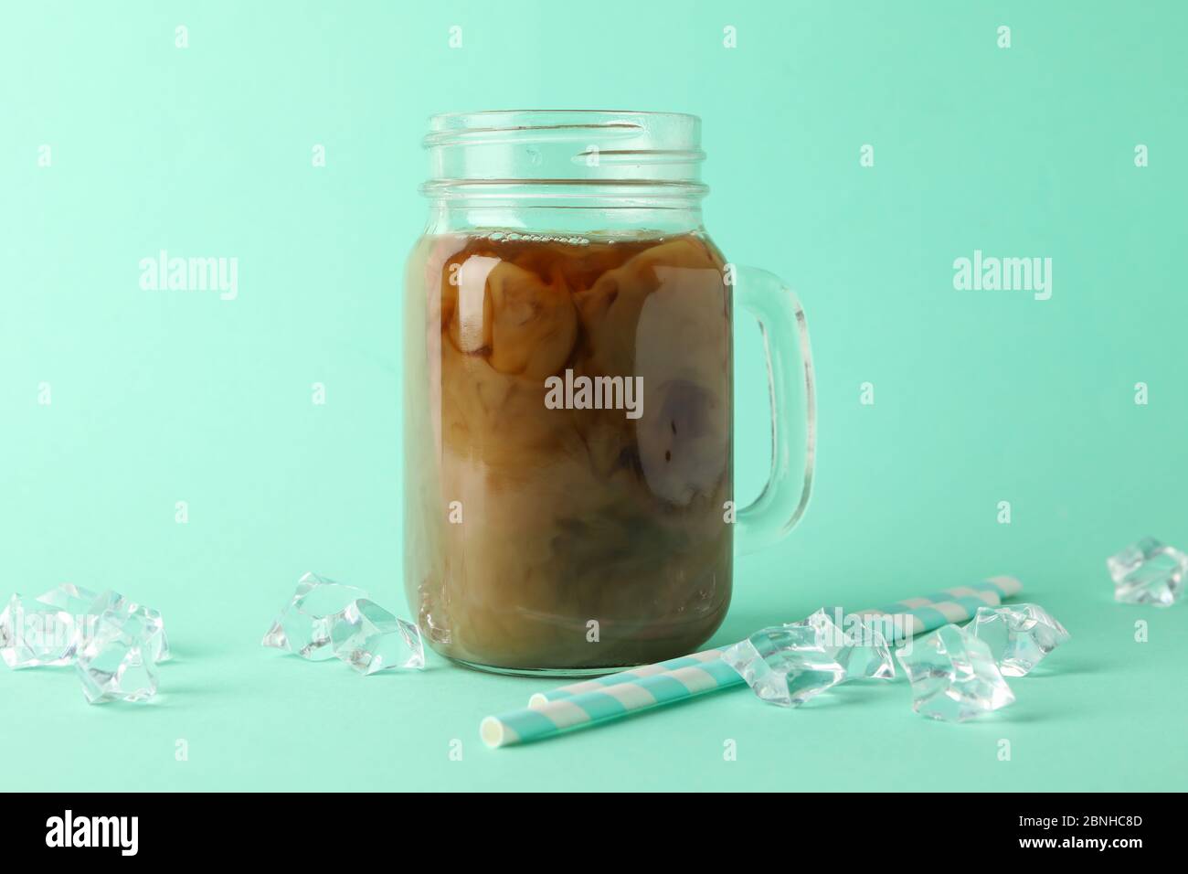 Bol de café glacé, glaçons et pailles sur fond de menthe Banque D'Images