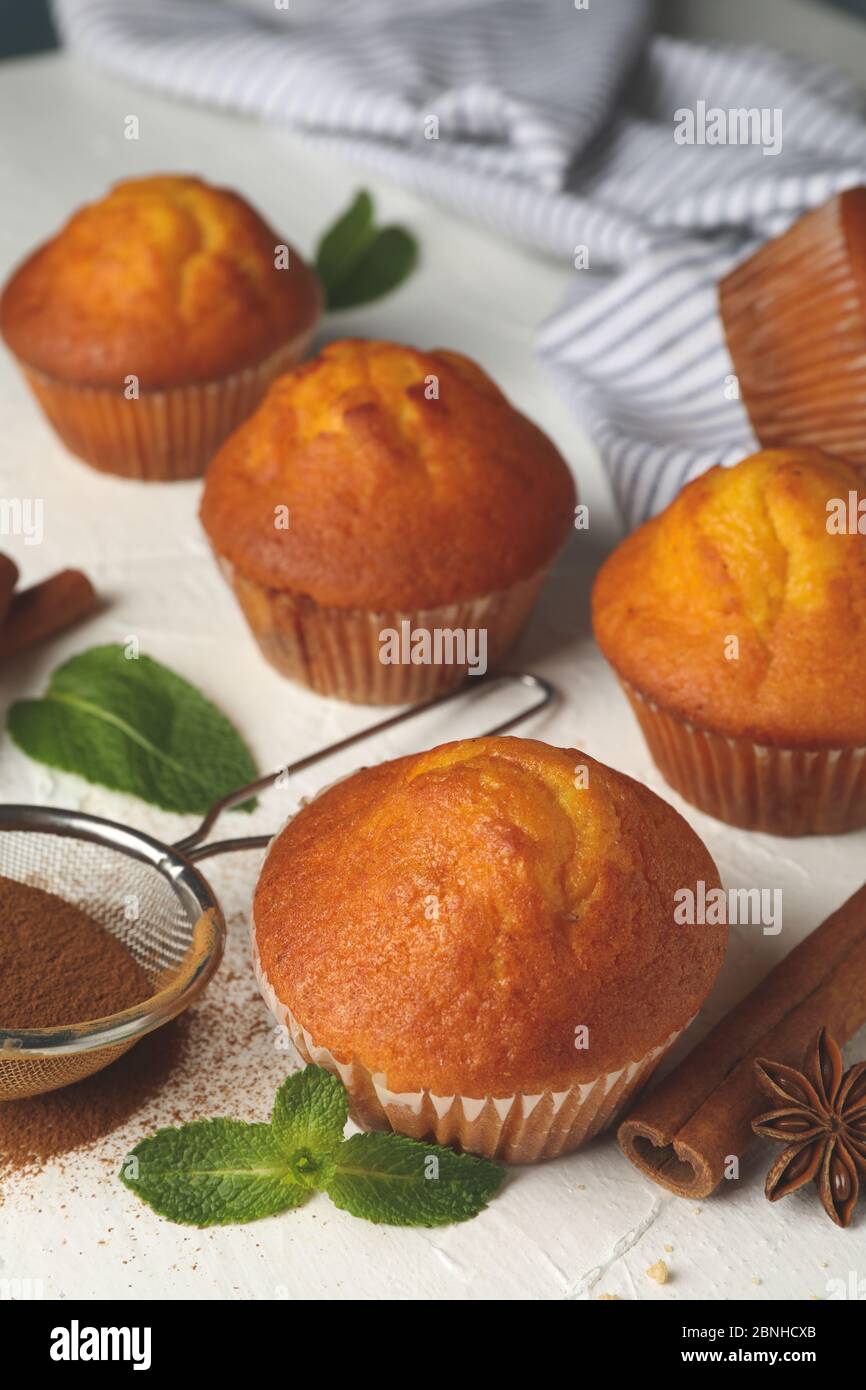 Composition avec muffins et cannelle sur fond blanc Banque D'Images