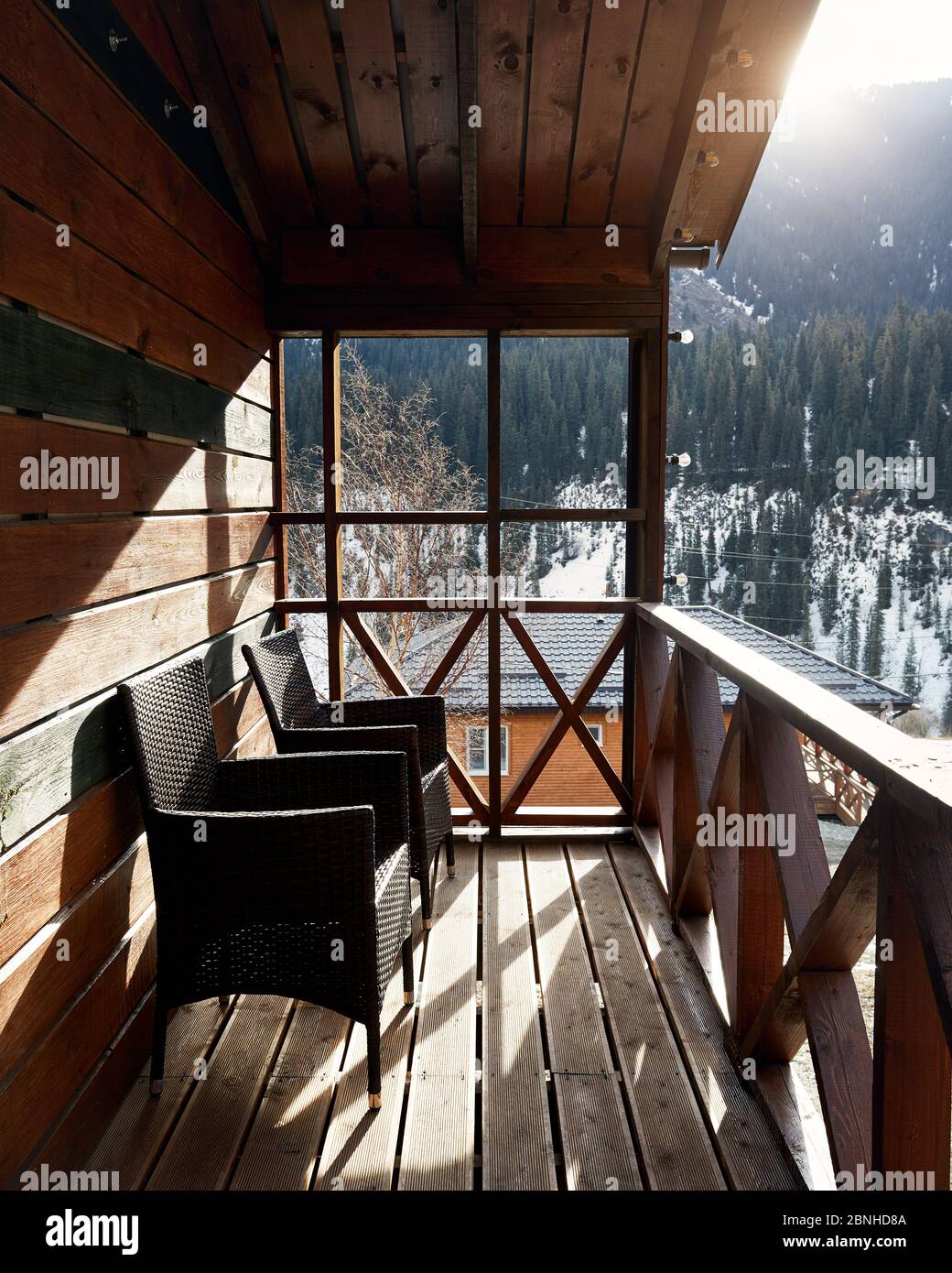 Terrasse de maison en bois avec chaises confortables dans la station de montagne au lever du soleil Banque D'Images