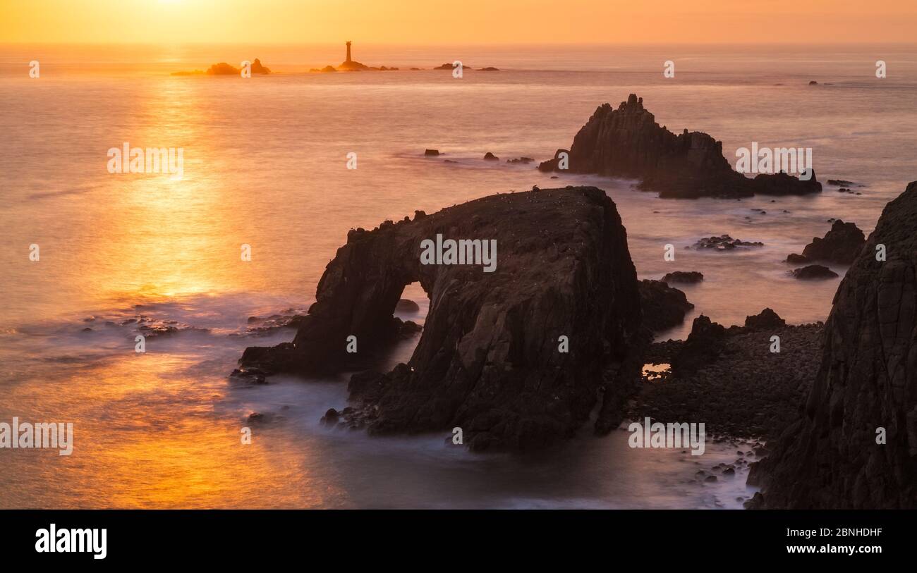 Coucher de soleil sur Enys Dodnan, Phare blindé de Chevalier et de Longships, Cornouailles, Angleterre. Avril 2014. Banque D'Images