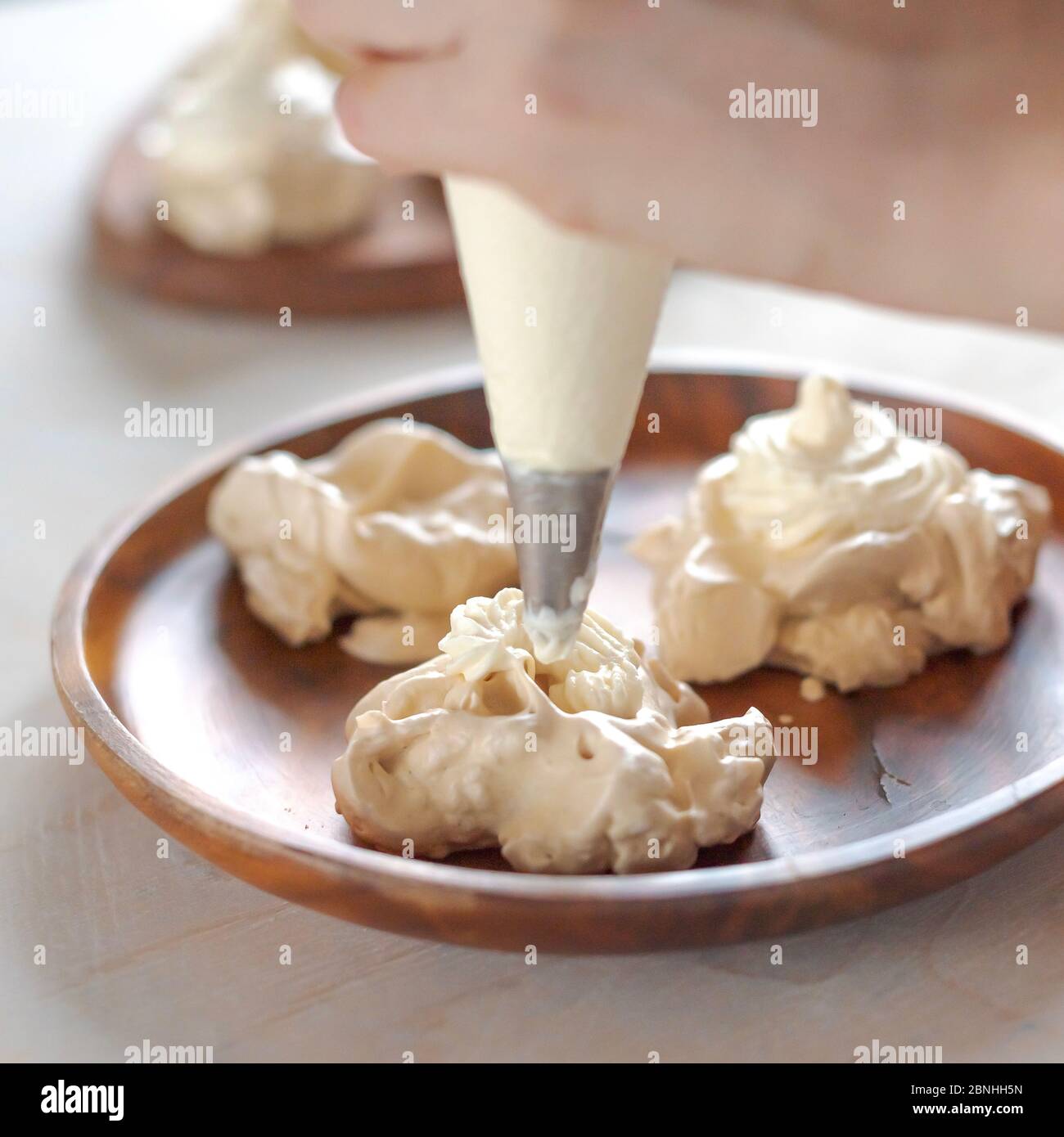Le processus de création de dessert Pavlova, décorant la meringue avec la crème Banque D'Images