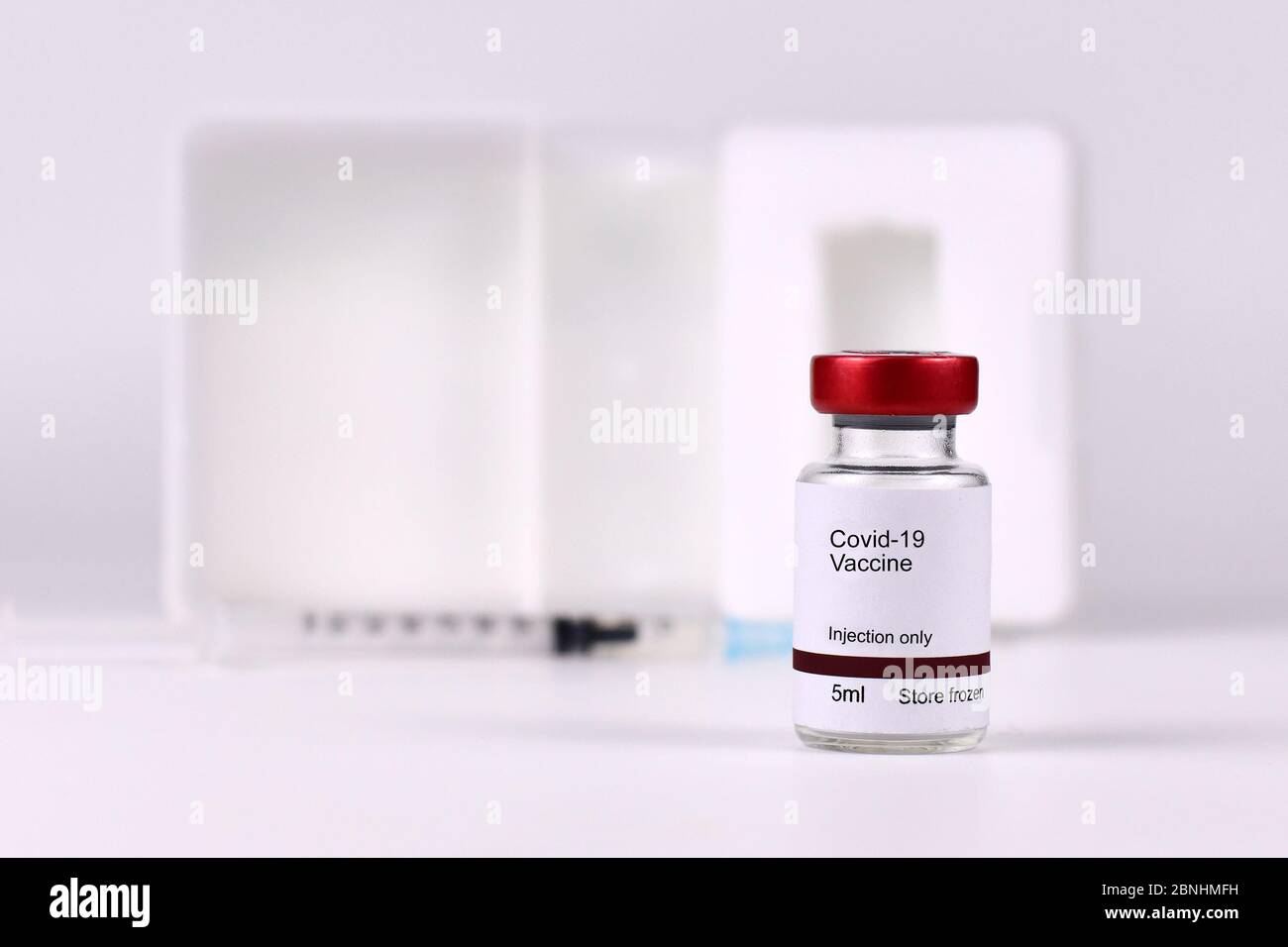 Vaccin contre le coronavirus concept avec petite bouteille avec texte « vaccin Covid-19 » avec seringue dans un fond flou Banque D'Images